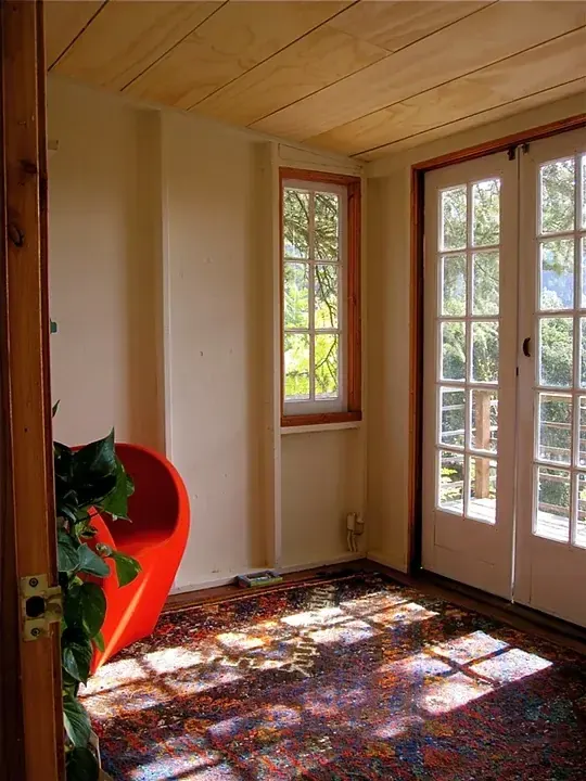 ADU interior with cedar paneling and a red reading chair