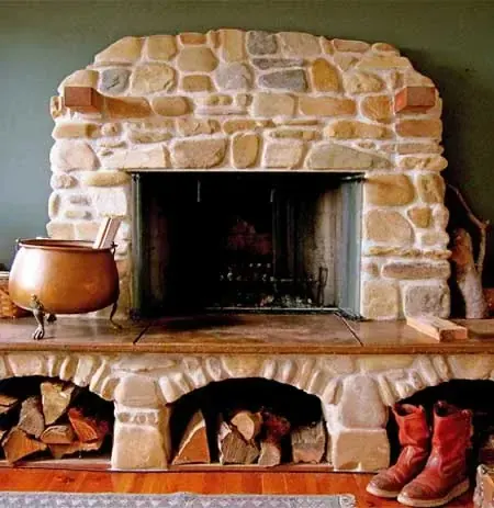 Hand-laid stone fireplace with carved limestone mantel and woodbox alcoves