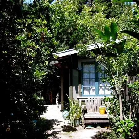 Painted garden cabin tucked among magnolia and citrus