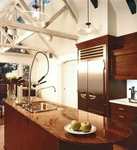 Vaulted kitchen with exposed king-post trusses and walnut cabinetry