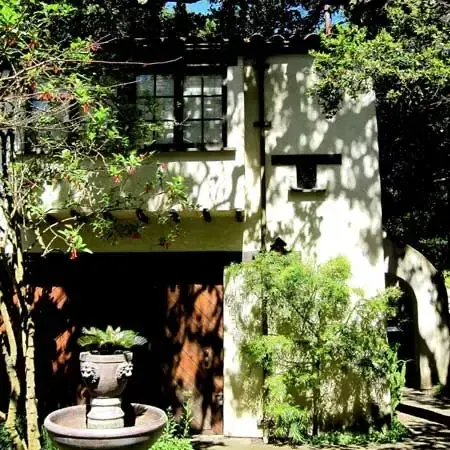 Two-story stucco cottage with arched entry and tile roof